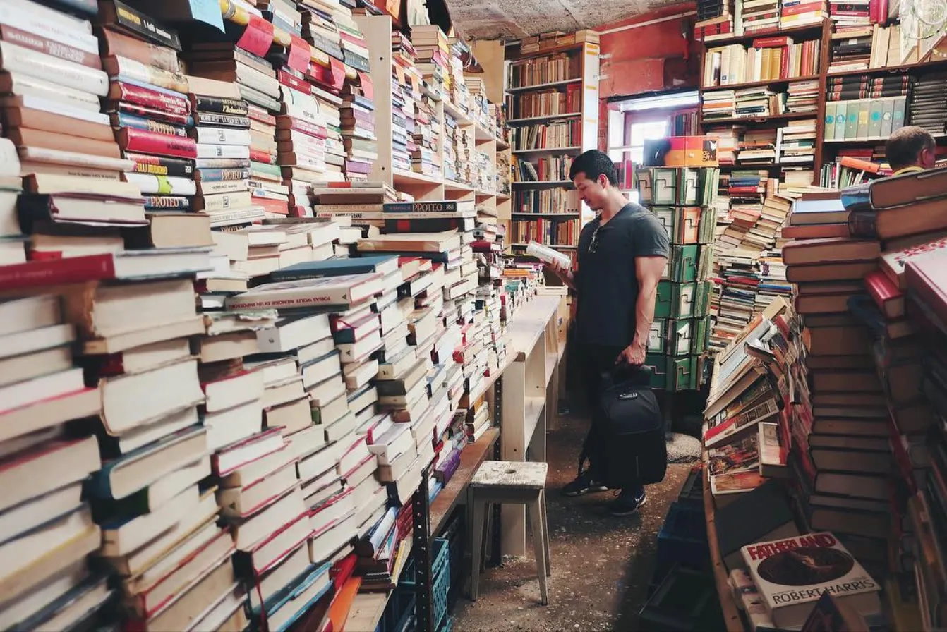 René Velarde browsing books in a crowded bookstore in Venice